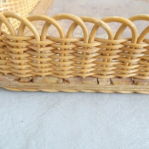 May include: A woven wicker tray with a natural wood finish. The tray has a scalloped edge and a woven base.