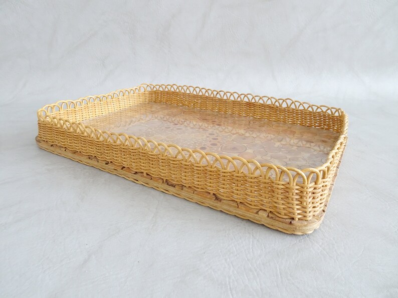 May include: A rectangular wicker tray with a woven design and a clear glass insert. The tray has a scalloped edge.
