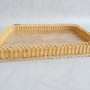 May include: A rectangular wicker tray with a scalloped edge and a clear glass insert. The tray is made of natural woven wicker and has a light brown color.
