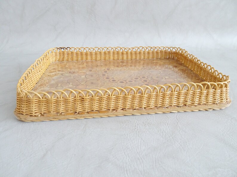 May include: A rectangular wicker tray with a scalloped edge and a clear glass insert. The tray is made of natural woven wicker and has a light brown color.