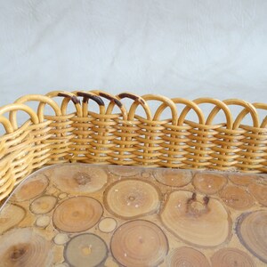 May include: A woven wicker tray with a scalloped edge and a clear glass insert with a wood veneer design. The wood veneer is made of small, round pieces of wood.