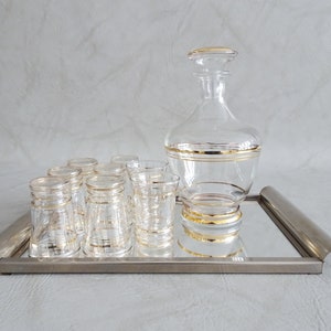 Glass carafe with glasses and mirror tray