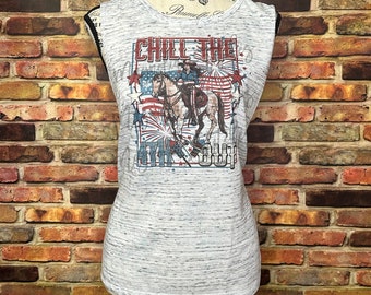 May include: A gray sleeveless shirt with a graphic print of a cowboy riding a horse with fireworks and the text "Chill the 4th Out".