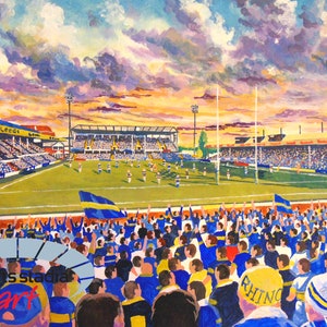 Puede incluir: Una pintura de un estadio de rugby con una multitud de aficionados animando. El cielo es de un naranja y un morado vibrantes con nubes. El campo es verde y las gradas están llenas de gente que lleva camisetas azules y amarillas. Las palabras "Leeds" y "Rhino" son visibles en las camisetas.