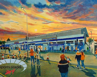 May include: A painting of a football stadium with fans walking towards the entrance. The sky is a vibrant orange and yellow with clouds. The stadium is a light blue and white building with the words "Erith Town Football Club" on the front.