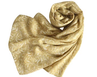May include: A yellow scarf with a white floral pattern. The scarf is made of a soft, lightweight fabric and is perfect for adding a touch of elegance to any outfit.