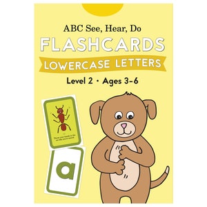May include: A set of flashcards for children ages 3-6. The flashcards feature lowercase letters and illustrations. The cover shows a brown dog with a yellow background. The text on the cover reads "ABC See, Hear, Do Flashcards Lowercase Letters Level 2. Ages 3-6".