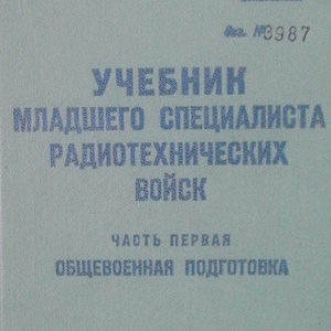 May include: A teal-colored book titled "Учебник младшего специалиста радиотехнических войск" with the text "Часть первая Общевоенная подготовка" and "Военное издательство Министерства обороны СССР Москва - 1952" printed on the cover.