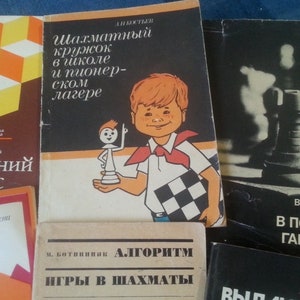 May include: A collection of five vintage chess books with colorful covers. The books are titled "Шахматный кружок в школе и пионер-ском лагере", "Последний шанс", "АЛГОРИТМ ИГРЫ В ШАХМАТЫ", "В ПОИСКАХ ГАРМОНИИ", and "ВИД ...".