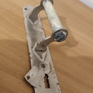 May include: A silver door handle with a white and blue marble-like knob. The handle is attached to a metal plate with a keyhole.