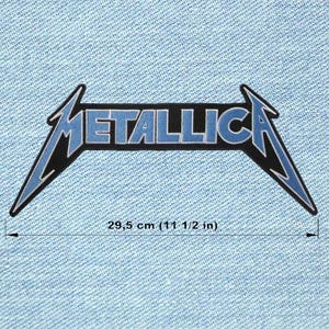 Op de afbeelding: Een blauw en zwart Metallica logo-patch, met een lengte van 29,5 cm. Het woord "METALLICA" staat in blauwe blokletters met een zwarte omlijning, tegen een zwarte achtergrond. De patch bevindt zich op een lichtblauwe denim achtergrond.