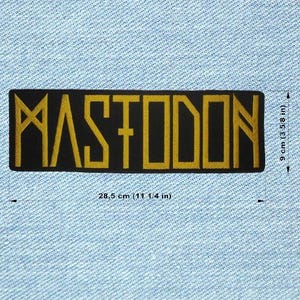 Puede incluir: Un parche rectangular negro con la palabra "MASTODON" en letras doradas. El parche mide 28,5 cm de largo y 9 cm de alto. Este parche está diseñado para coser en ropa o bolsos.