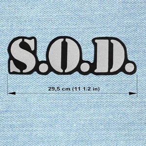 Può includere: Una toppa ricamata nera e argento con le lettere "S.O.D.". La toppa è lunga 29,5 cm. Le lettere sono in grassetto, a blocchi, con bordo nero e riempimento argento. La toppa è su uno sfondo di denim blu chiaro.