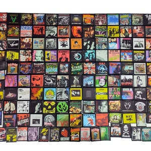 Puede incluir: Una colección de 100 parches de bandas de punk rock, con nombres de bandas como Black Flag, Green Day, The Ramones y NOFX. Los parches son todos en blanco y negro con acentos de colores y están dispuestos en una cuadrícula.
