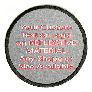 Op de afbeelding: Ronde patch met een grijze reflecterende oppervlakte en een zwarte rand. De tekst "Your Custom Text or Logo on REFLECTIVE MATERIAL Any Shape or Size Available" is rood.