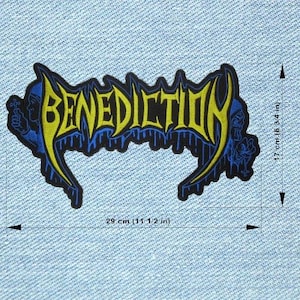Op de afbeelding: Een zwart, blauw en geel geborduurd embleem met het woord "BENEDICTION". Het embleem is 29 cm breed en 17 cm hoog. Het ontwerp bevat gestileerde letters en decoratieve elementen.