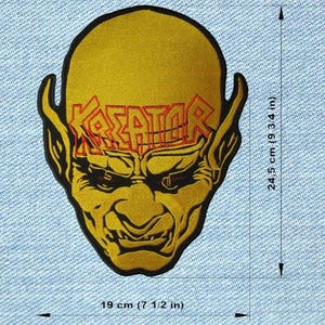 Peut inclure: Écusson jaune et noir représentant un visage de démon stylisé avec le mot "KREATOR" en lettres rouges. Le patch mesure 19 cm de large et 24,5 cm de haut. Le patch est sur un fond en denim bleu.