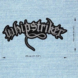 Peut inclure: Un écusson brodé noir et gris avec le mot "Whipstriker" dans une police gothique. L'écusson mesure 29 cm de large et 14,5 cm de haut. L'écusson est sur un fond en denim bleu clair.