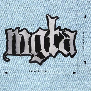 May include: A black and white embroidered patch with the word "mata" in a gothic font. The patch is 29 cm wide and 19.5 cm tall. The patch is on a light blue denim background.