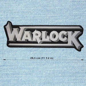 May include: A rectangular patch with the word "WARLOCK" in gray, outlined in black and silver. The patch is 11 1/2 inches long and is set against a light blue denim background. The text has a 3D effect.