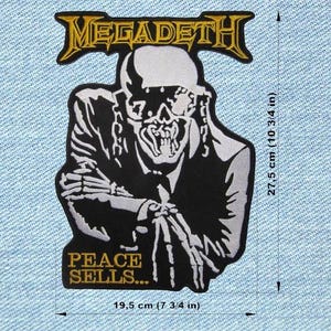 Peut inclure: Écusson noir et blanc avec le logo du groupe Megadeth et une figure squelettique en costume. L'écusson mesure 19,5 cm de large et 27,5 cm de haut. Le texte "PEACE SELLS..." est en bas.