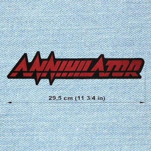 Peut inclure: Un écusson brodé rouge et noir avec le mot "ANNIHILATOR" dans une police de caractères audacieuse et stylisée. La longueur de l'écusson est de 29,5 cm, sur un fond en denim bleu clair.