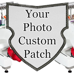 Może przedstawiać: Biała maszyna do haftowania z kolorowymi szpulkami nici. Niestandardowa naszywka z napisem "Your Photo Custom Patch" znajduje się na środku. Naszywka ma kształt tarczy z czarną, haftowaną obwódką. Widoczne są czerwone czapki bejsbolowe.