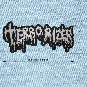 May include: Black and white patch featuring the word "TERRORIZER" in a dripping, gothic font. The patch measures 28.5 cm long and 13 cm high. The patch is on a light blue denim background.