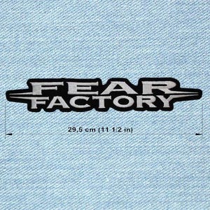Puede incluir: Parche bordado en blanco y negro con el texto "FEAR FACTORY". El parche mide 29,5 cm (11 1/2 pulgadas) de ancho y tiene un borde negro con letras blancas. Fondo de tela vaquera azul claro.