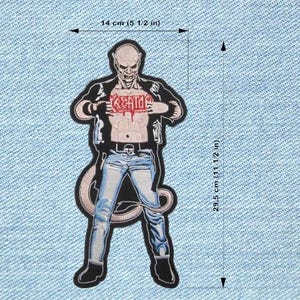 May include: Embroidered patch depicting a demonic figure with the word "KREATOR" on the chest. The patch measures approximately 14 cm wide and 29.5 cm tall. The figure wears a black jacket, blue jeans, and black boots. The patch has a black border.