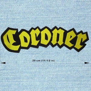Könnte beinhalten: Ein gelb-schwarzer, gestickter Aufnäher mit dem Wort "Coroner" in einer stilisierten Schriftart. Der Aufnäher ist 29 cm (11 1/2 Zoll) lang und vor einem hellblauen Jeanshintergrund platziert. Der Aufnäher ist ein dekorativer Artikel.