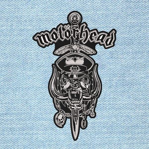 Peut inclure: Un écusson brodé en noir et blanc représentant le logo Motörhead au-dessus d'une épée centrale. Le motif inclut une créature menaçante portant une casquette militaire, entourée de chaînes, d'un petit crâne et d'une croix sur un fond en jean.