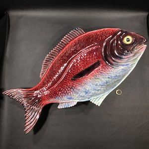 May include: A red and blue ceramic fish shaped serving dish. The fish has a detailed design with scales and a large eye.
