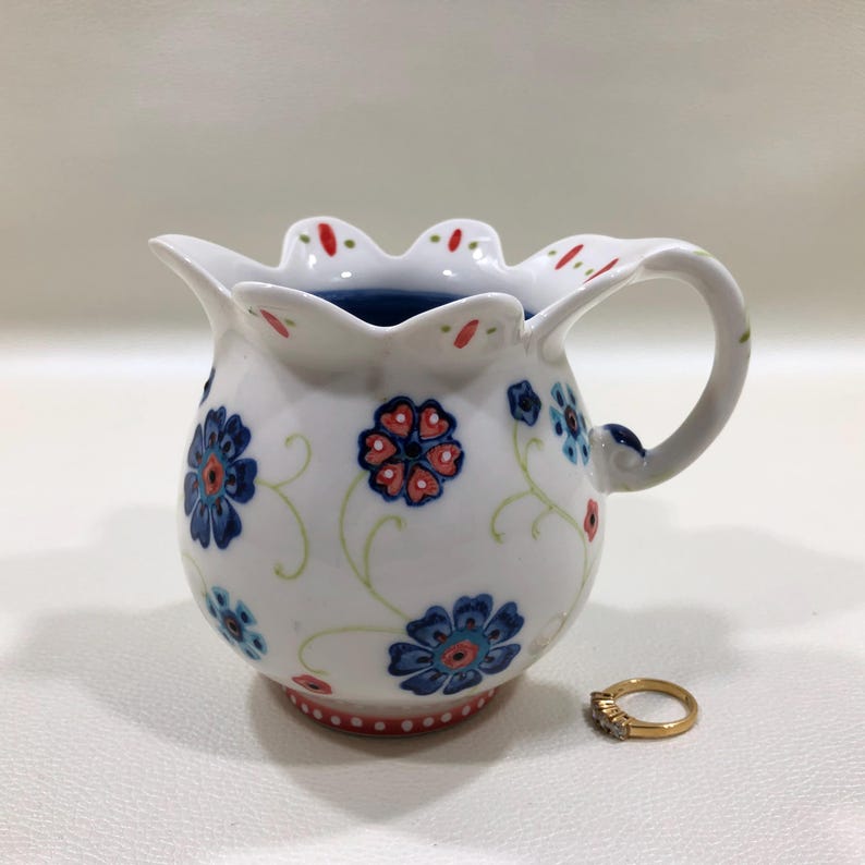 Jarra de leche/nata de cerámica pequeña, pintada a mano con motivos florales en azul y rojo, estilo bohemio veraniego. imagen 3