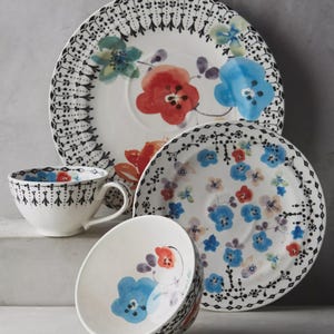 May include: A set of three ceramic nesting bowls in shades of blue, green, and white. The bowls feature a speckled glaze and a simple, modern design. The largest bowl measures approximately 6 inches in diameter.