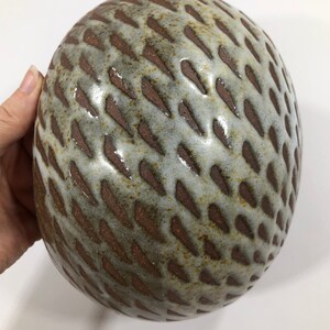 以下が含まれることがあります： 茶色のテクスチャパターンが施された白いセラミックボウル。ボウルは丸く、滑らかで光沢のある仕上げです。
