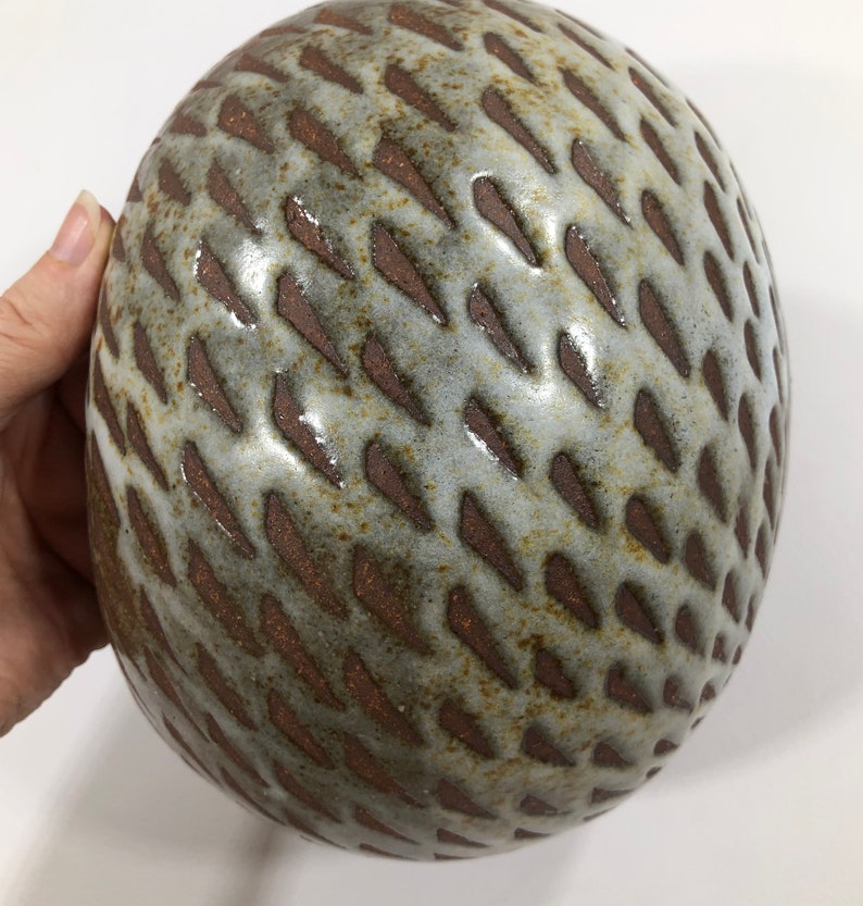 以下が含まれることがあります： 茶色のテクスチャパターンが施された白いセラミックボウル。ボウルは丸く、滑らかで光沢のある仕上げです。