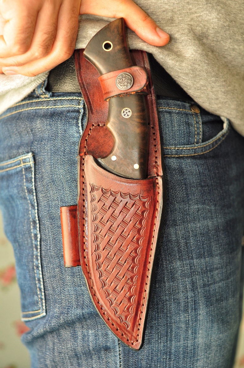 Knife held in hand demonstrating precision grip for tracking and field cuts.