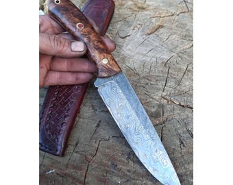 Faca de caça em aço damasco genuíno – Cabo em madeira de castanheiro – 150 camadas – Fabricada por ferreiro – Ideal para atividades ao ar livre/camping – Bainha em couro – Nº 57