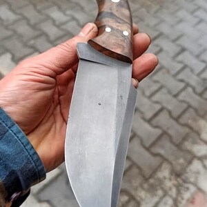 Outdoor style presentation of knife and sheath on textured natural background.