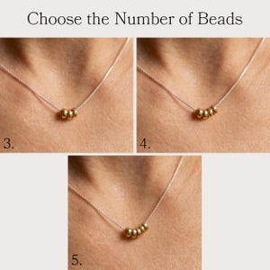 May include: A silver necklace with gold beads. The image shows three variations of the necklace, each with a different number of gold beads: three, four, and five. The text at the top reads "Choose the Number of Beads."
