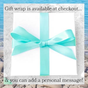 Może przedstawiać: Białe pudełko prezentowe z turkusową wstążką zawiązaną w kokardę. Na obrazku widnieje tekst "Gift wrap is available at checkout... & you can add a personal message!"