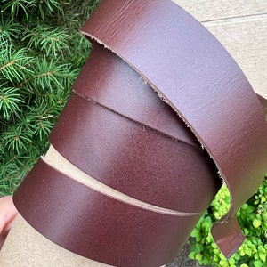 May include: A roll of dark brown leather straps. The leather is smooth and has a slight sheen.
