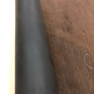 May include: A roll of dark brown leather with a smooth, even texture. The leather is rolled up tightly and the edges are visible.