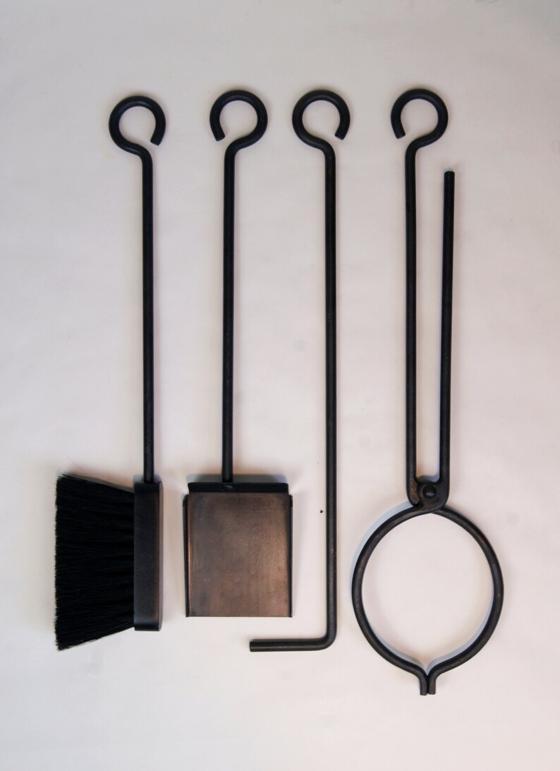 May include: A set of four black fireplace tools with a brush, shovel, poker, and tongs. The tools have a simple design with a loop at the top of each handle.