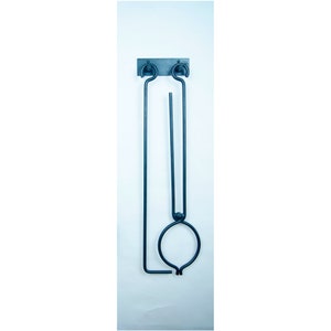 May include: A black metal fireplace tool set with a poker and tongs hanging on a wall mount. The tools are made of wrought iron and have a rustic finish.
