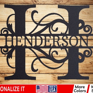 May include: Black metal monogram with the letter "H" and the name "Henderson" in a decorative script font. The letter is adorned with ornate scrollwork.