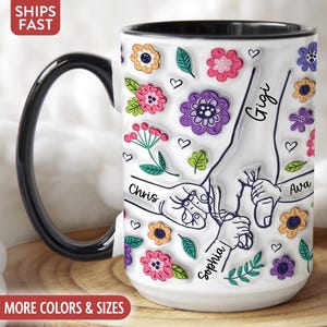 Puede incluir: Taza de caf&eacute; de cer&aacute;mica blanca con asa negra. La taza tiene un dise&ntilde;o floral con huellas de manos y los nombres Gigi, Chris, Sophia y Ava.
