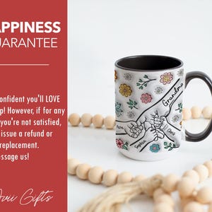 May include: White ceramic mug with a black handle. The mug has a design of hands holding each other with the names "Grandma", "Chris", "Sophia", and "Pasa" written on the hands. The mug is surrounded by small flowers and leaves.