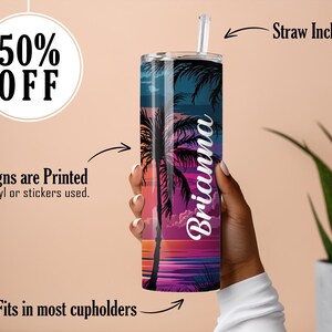 May include: A personalized stainless steel tumbler with a tropical sunset design and the name Brianna. The tumbler is in a hand and a straw is included.